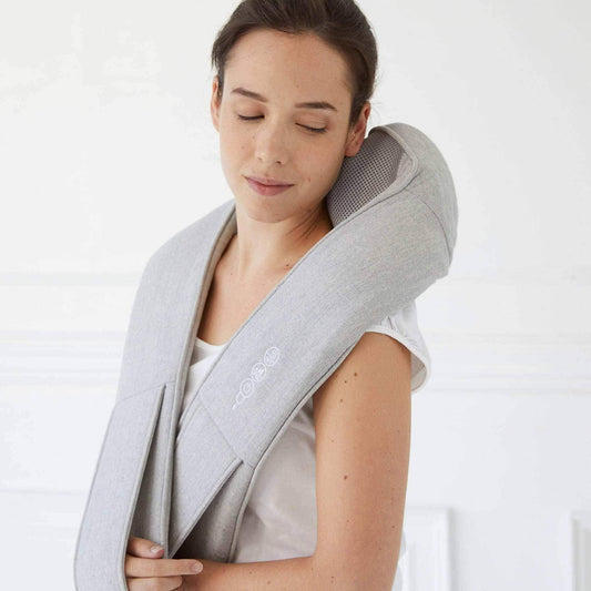 Masajeador de cuello y hombros Synca Wellness Quzy en gris usado por mujer para un masaje relajante