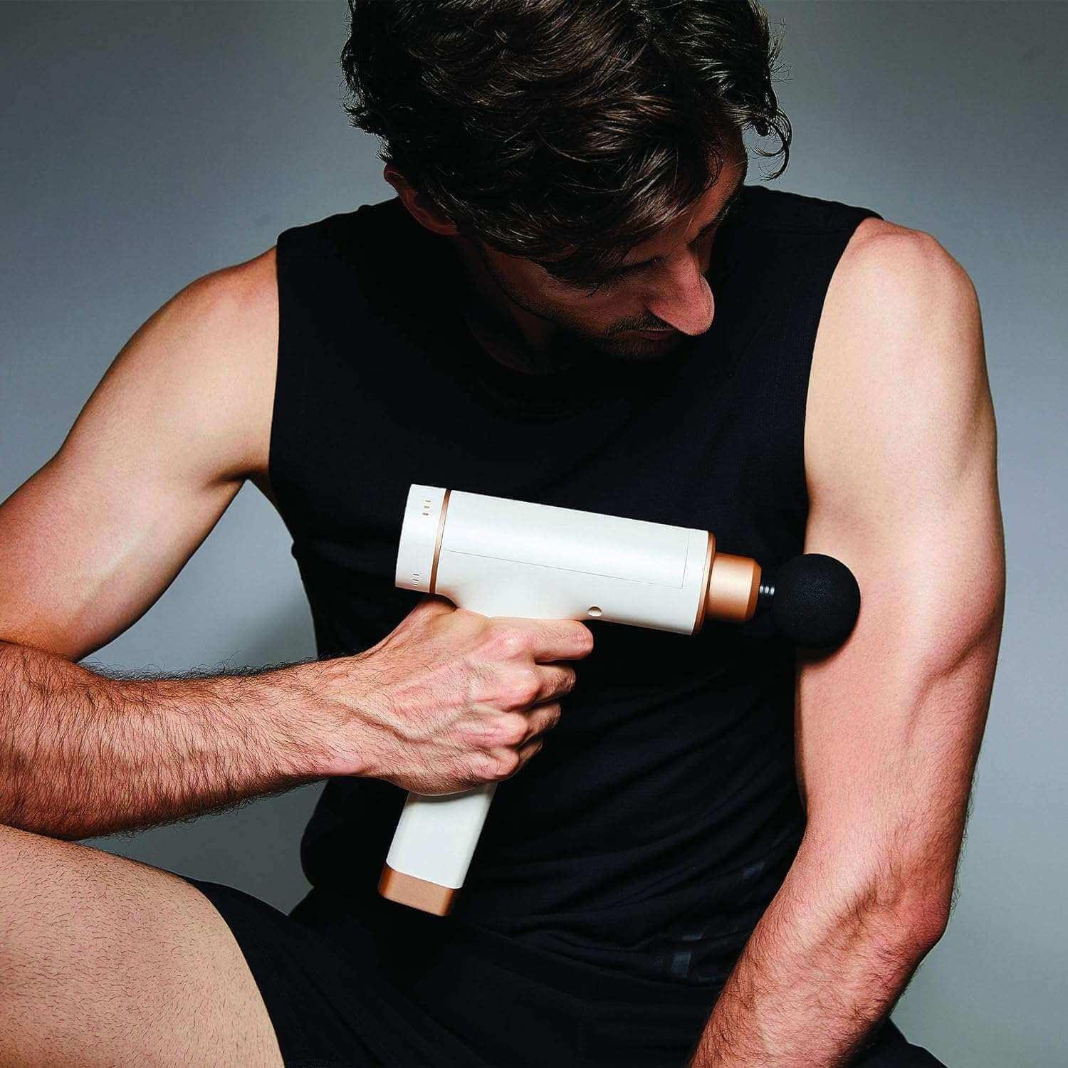 Synca Wellness Percussive Massage Gun used by man on arm muscles for deep tissue relief