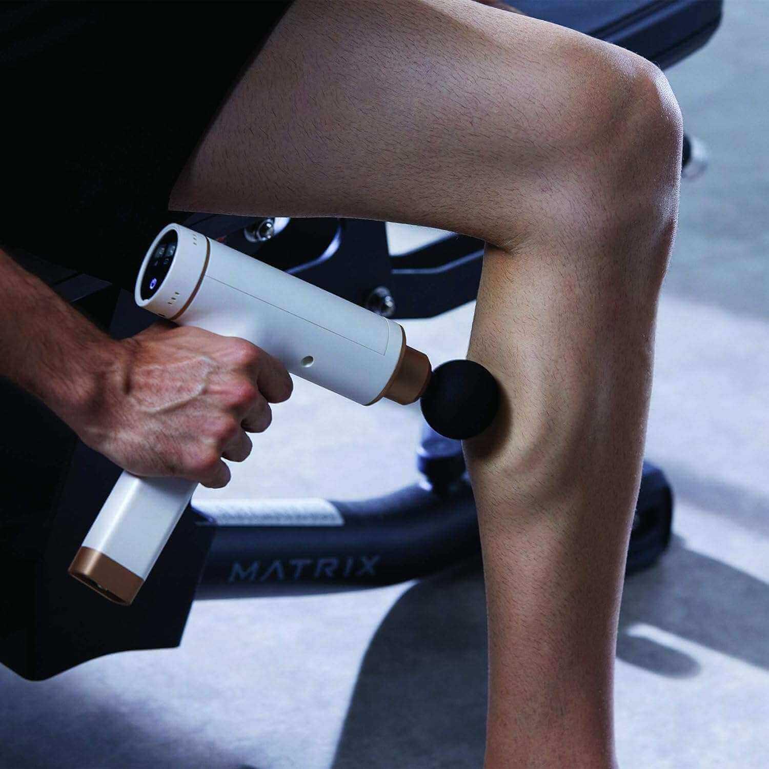 Synca Wellness electric percussive massage gun used on leg muscle for deep muscle relief