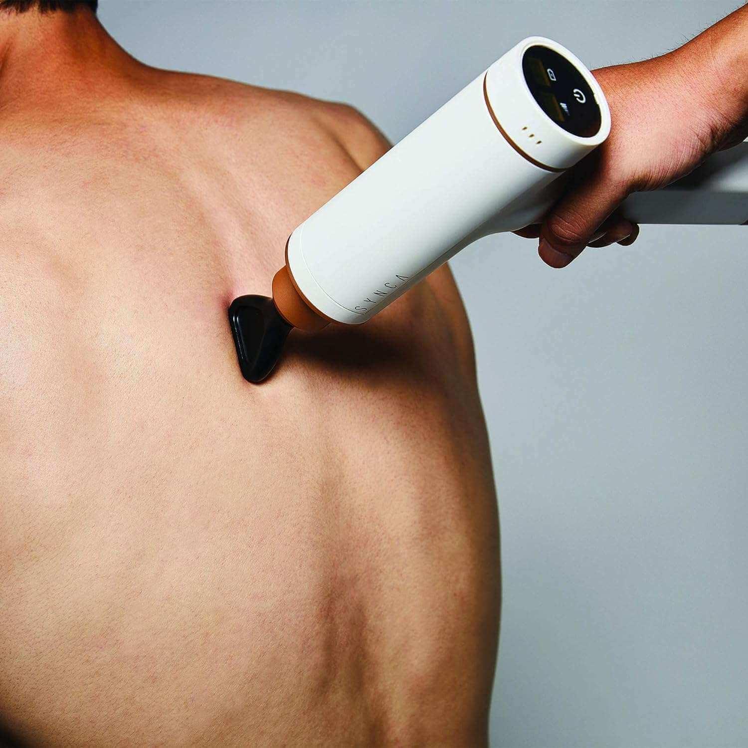 Synca Wellness Percussive Massage Gun in white used on upper back for muscle relief