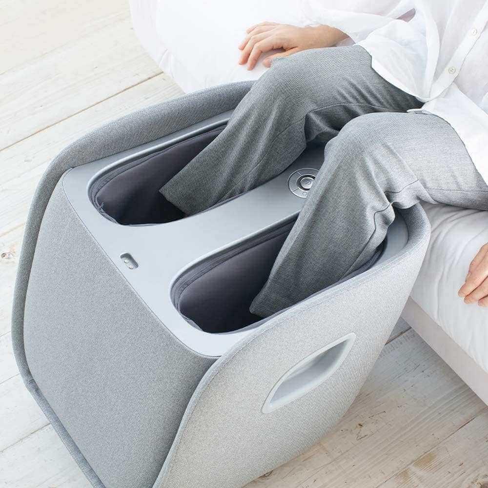 Synca Wellness REI Foot Massager in gray fabric with person using it on feet while seated