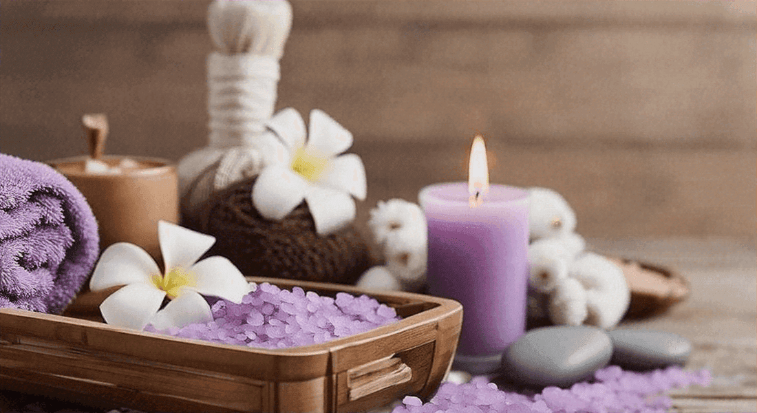 Spa arrangement of 5 Surprising Benefits of Owning a Synca Wellness Massage Chair with lavender bath salts, white flowers and a lit purple candle