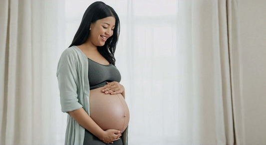 Pregnant woman smiling while gently holding her belly, promoting safety of massage chairs during pregnancy