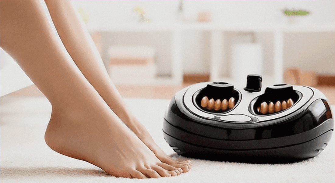 Black electric foot massager with dual roller wells beside bare feet, exploring the health benefits of regular use