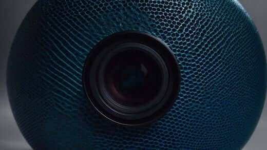 Kurodo E Review: The Perfect Commercial Massage Chair for You featuring a teal-blue textured mesh surface and central black circular detail