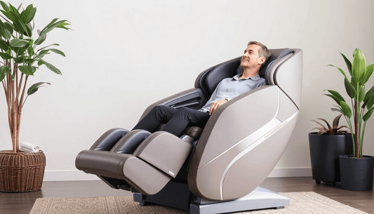 Massage chair safety shown with a man reclining in a two-tone gray upholstered chair with a padded footrest and enclosed sides.