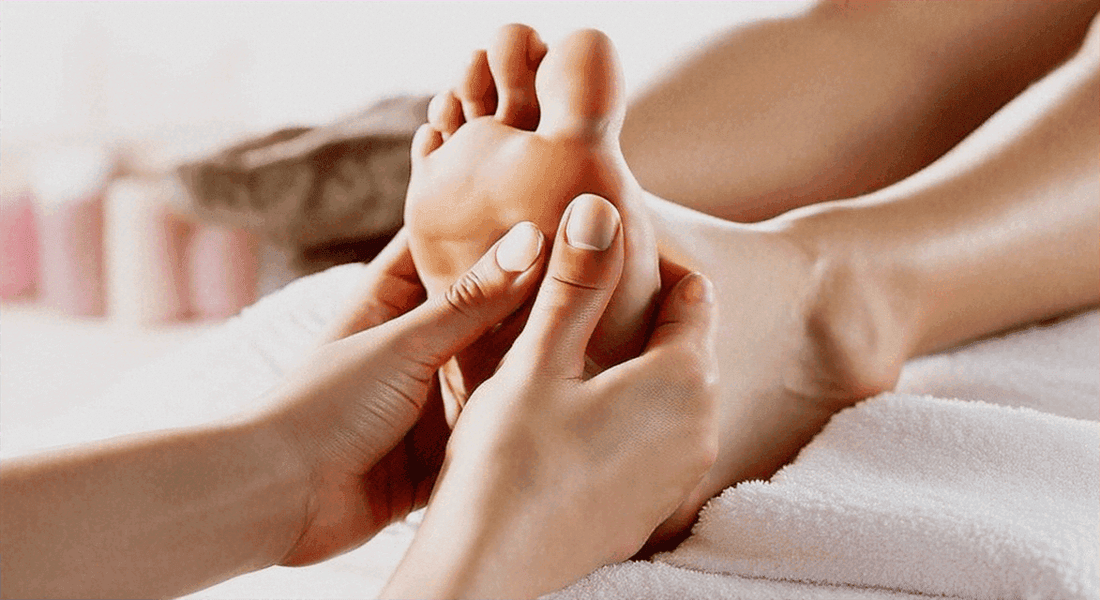 The Ultimate Guide to Choosing the Right Foot Massager for You: hands gently massage a bare foot with thumb pressure