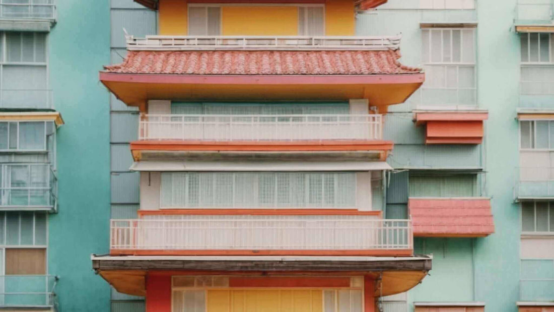Japanese building with an orange tiled roof, layered balconies, white railings, and mint-green walls; no massage chair visible