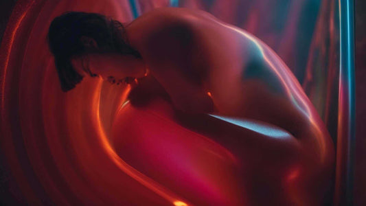 Why Massage Chairs Are Perfect for Relieving Post-Workout Muscle Pain, shown with a shirtless person curled forward in red light