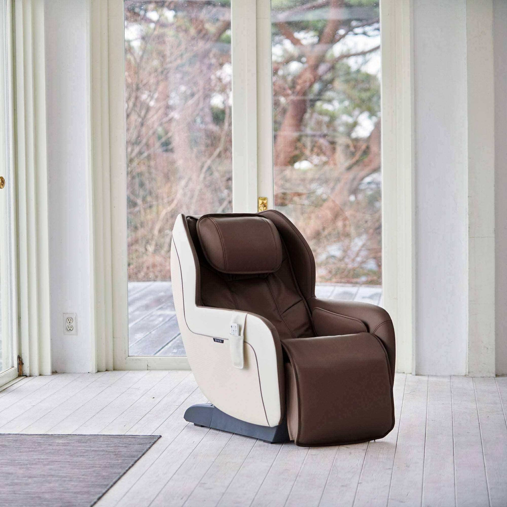 Ghế massage Synca Wellness CirC Plus màu nâu và trắng có điều khiển từ xa trong phòng hiện đại