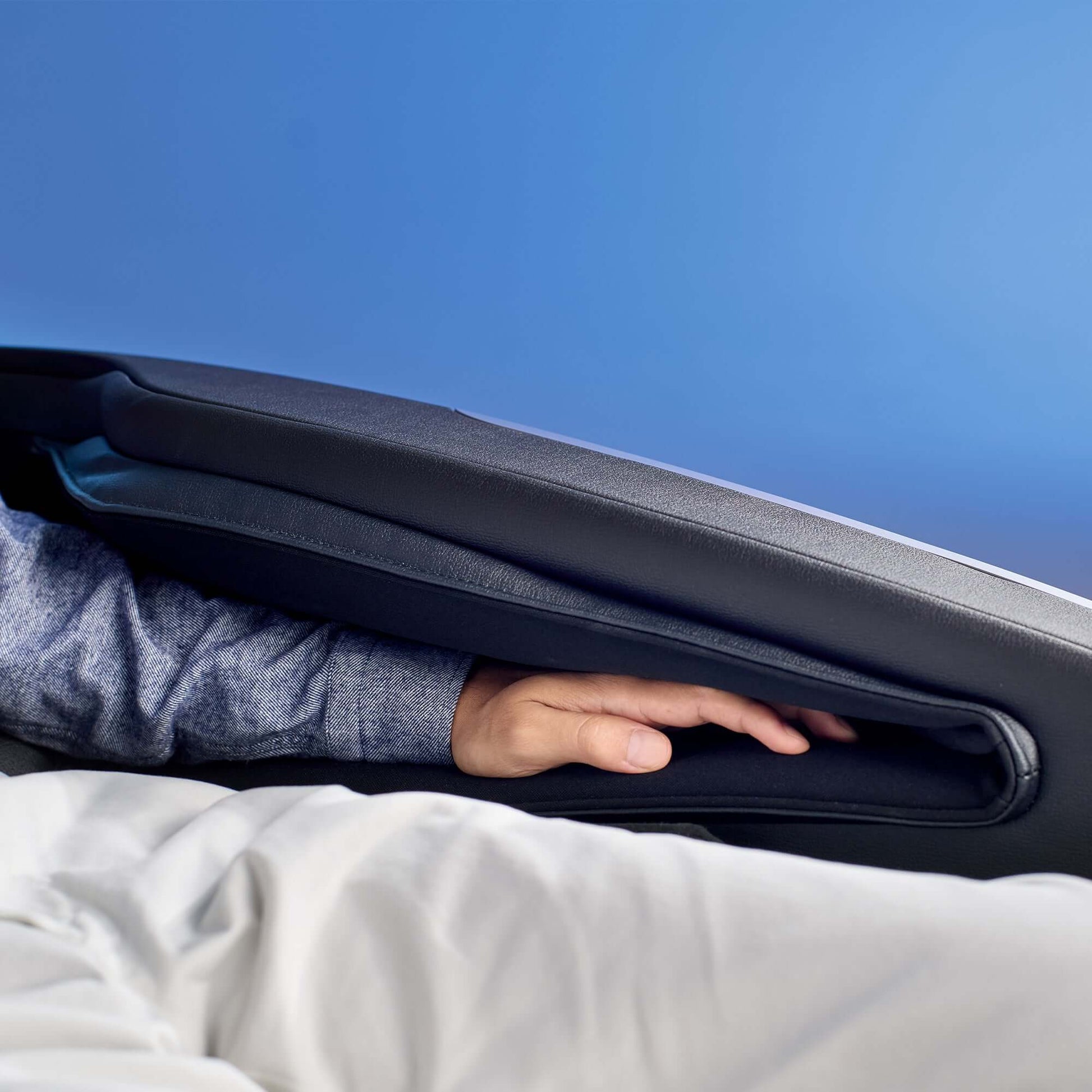 Hand placed inside the armrest of Fujiiryoki Cyber Relax Ai electric massaging chair showing cushioning and comfort