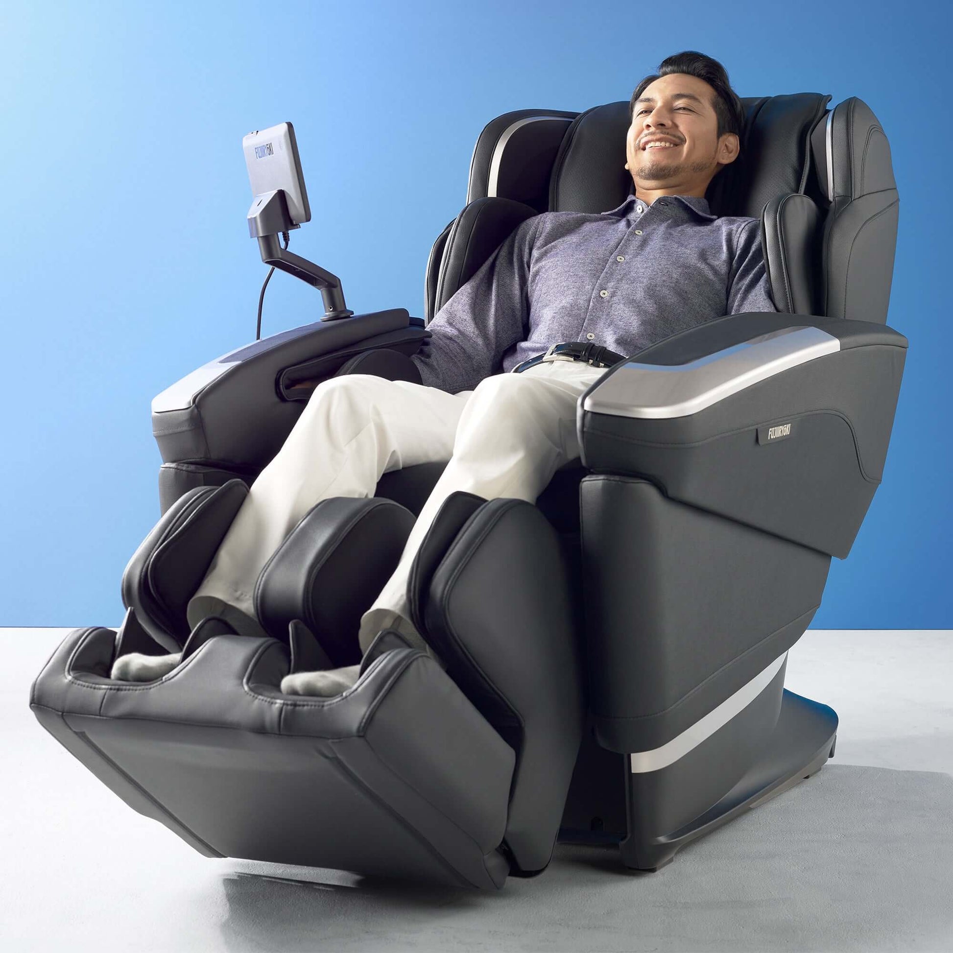 Man relaxing in Fujiiryoki Cyber Relax Ai electric massaging chair with foot and arm massage features