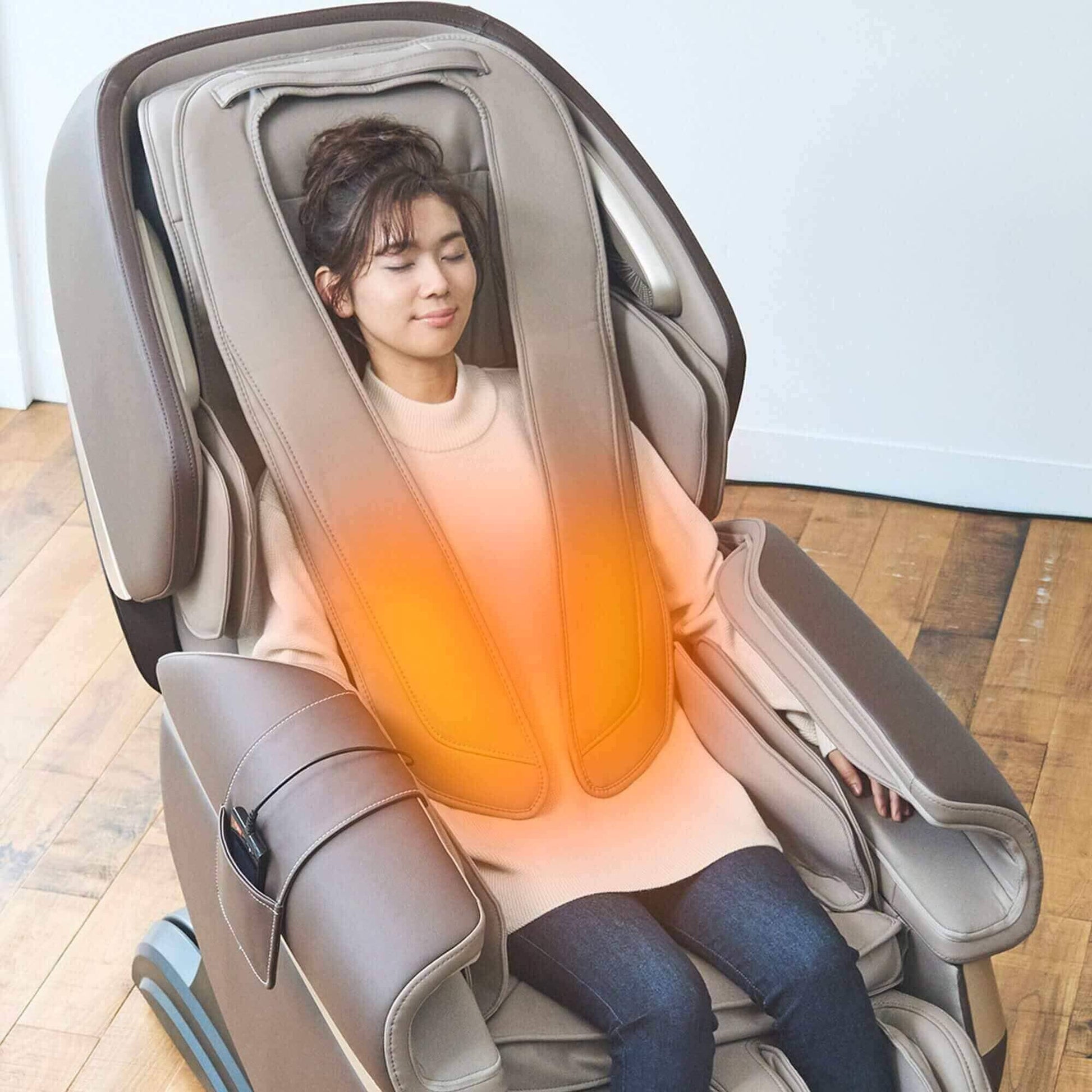 Woman relaxing in beige Fujiiryoki Calm Plus Massage Chair with heated torso therapy glow