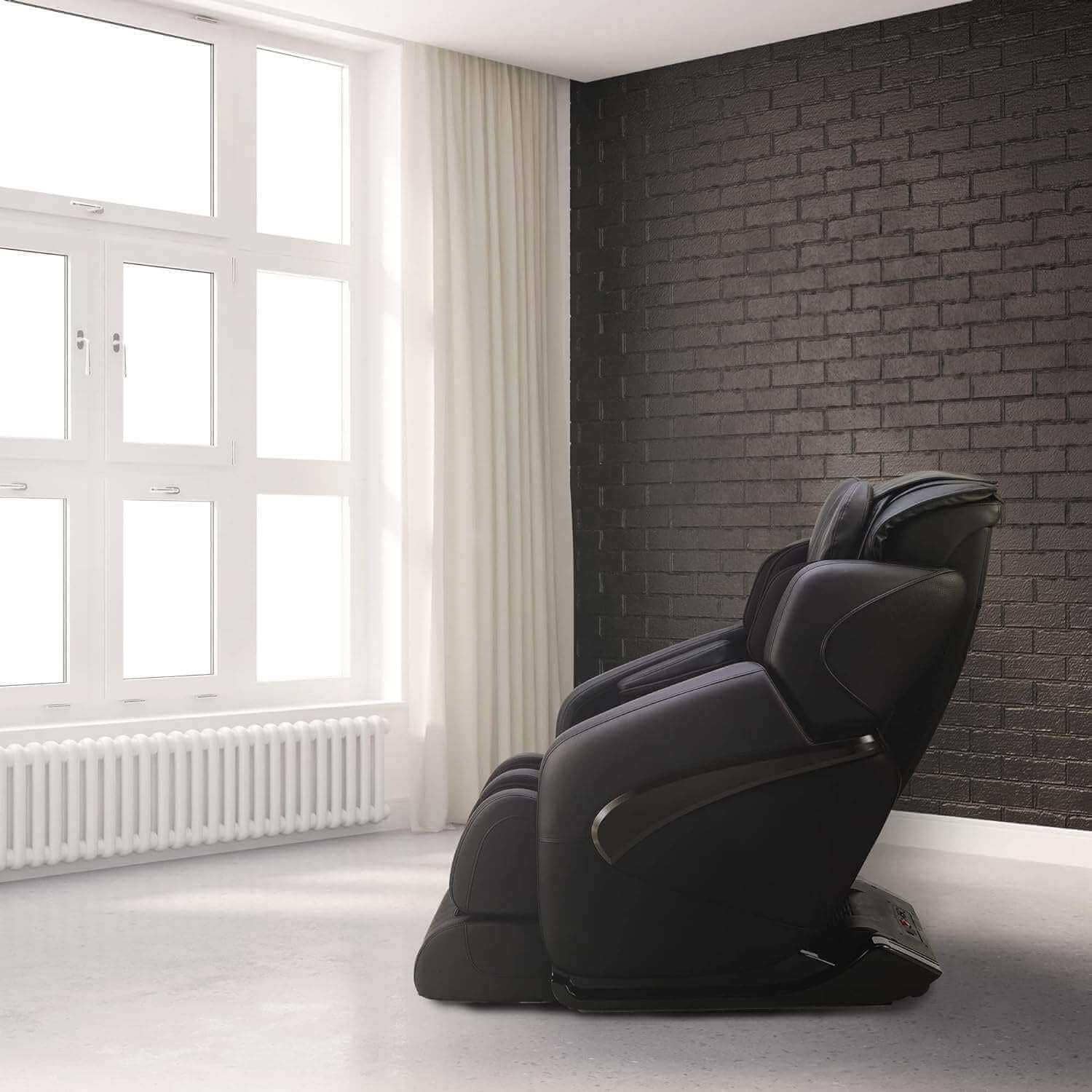 Fujiiryoki Jin massage chair in black positioned near large windows for relaxation