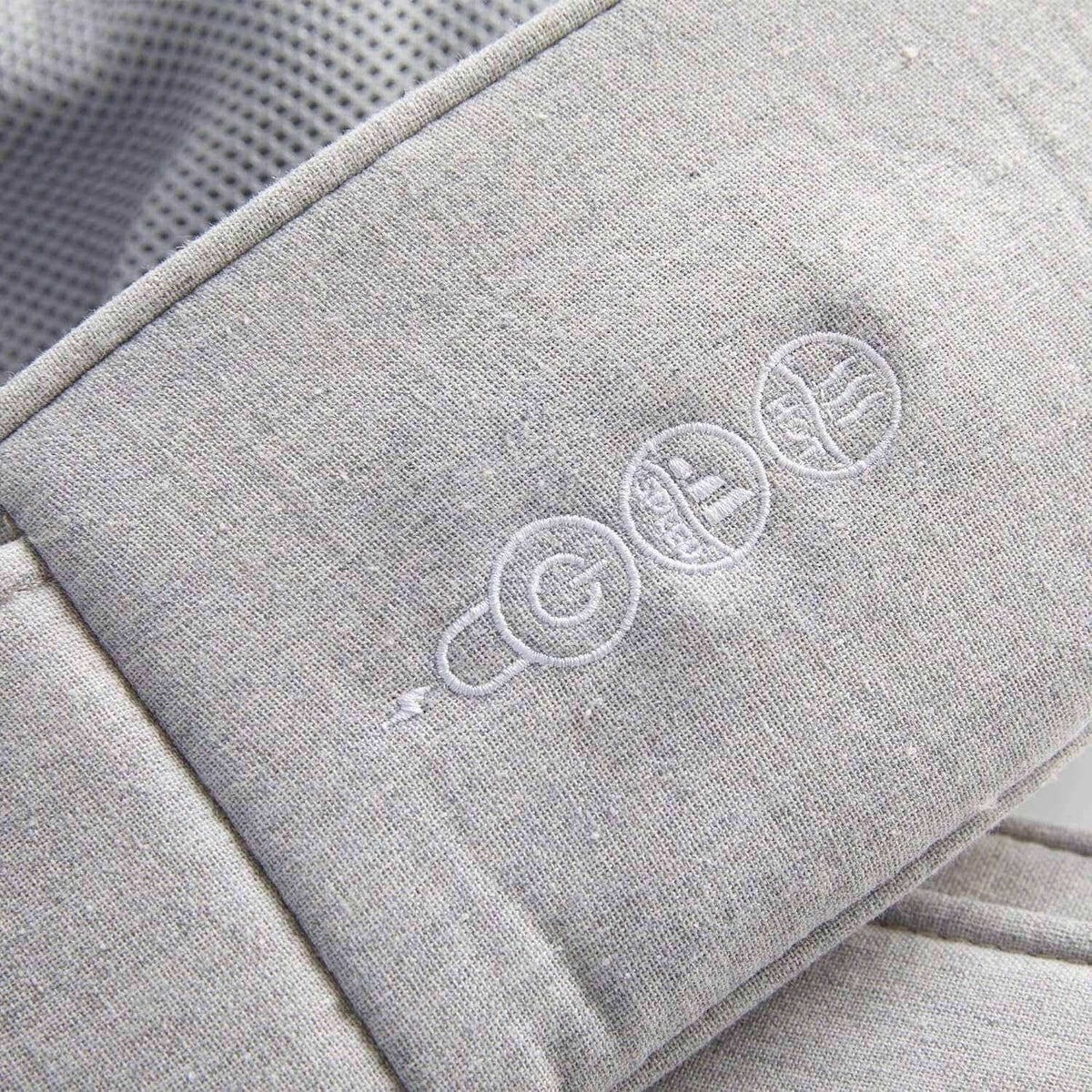 Neck and Shoulder Massager with a light gray fabric cover and white embroidered control icons on the padded surface