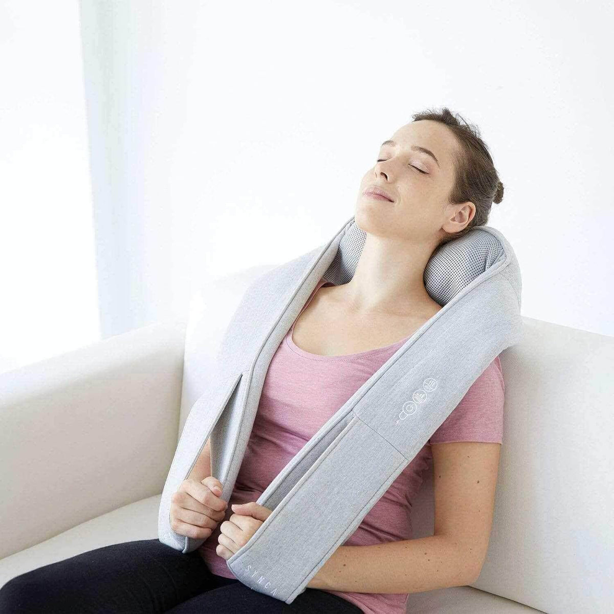 Neck and Shoulder Massager in light gray fabric draped around a woman’s neck, with padded kneading nodes